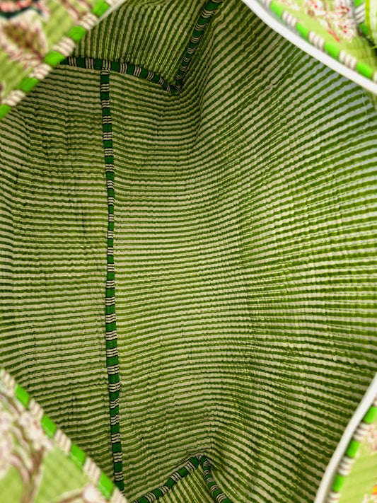 Close-up of the inside of a green woven bag with a floral patterned background