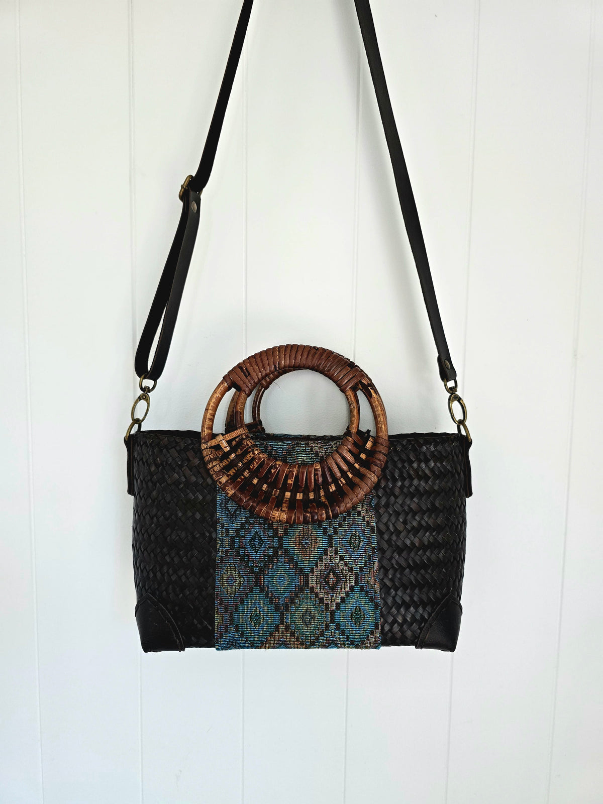 Woven handbag with a rattan handle on a white background