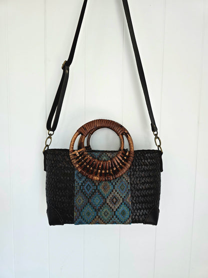 Woven handbag with a rattan handle on a white background