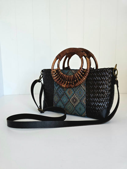 Woven handbag with a decorative rattan handle on a white background