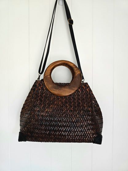Woven handbag with wooden handle on a white background