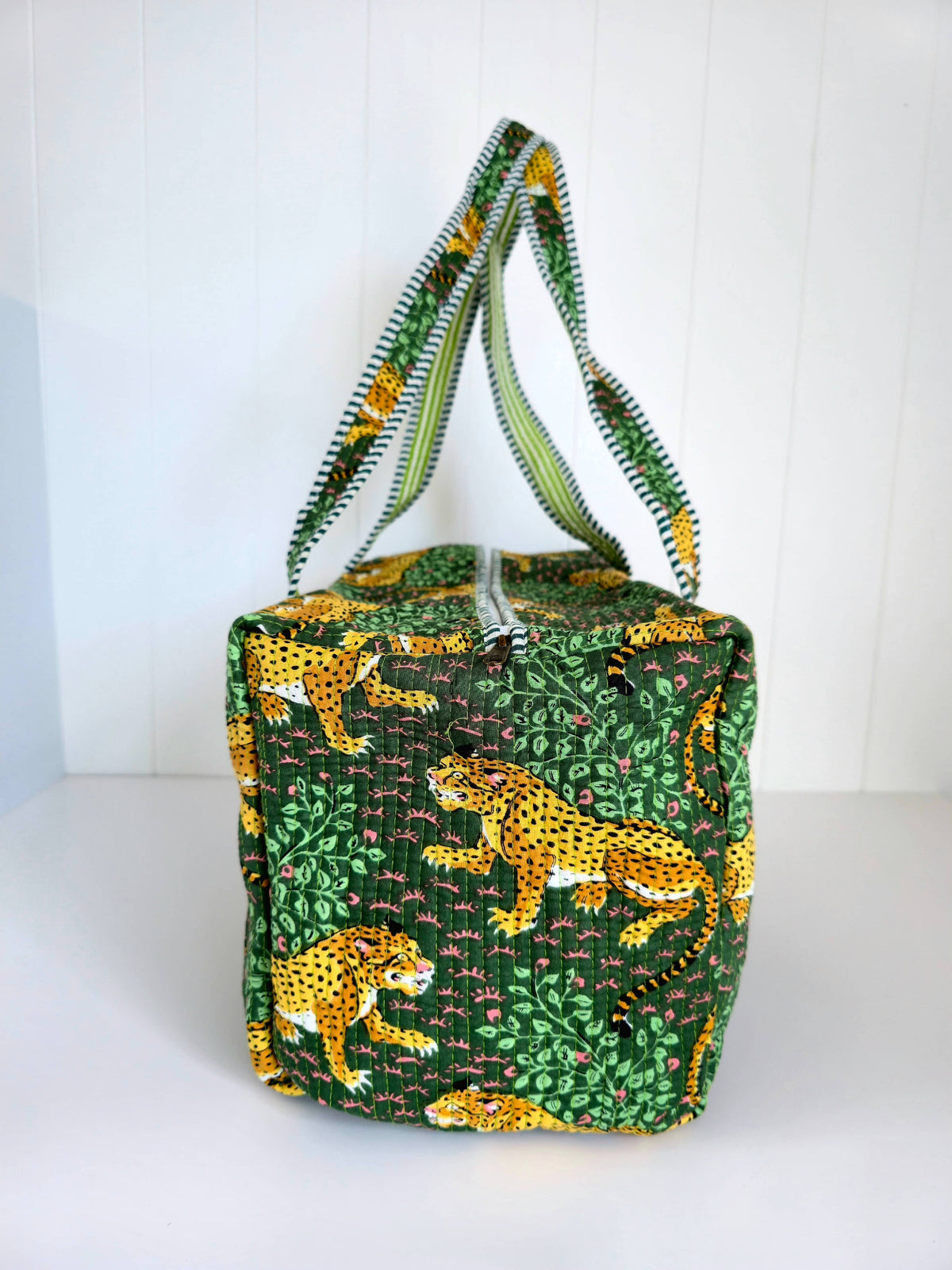 Green weekender bag with leopard pattern on a white background