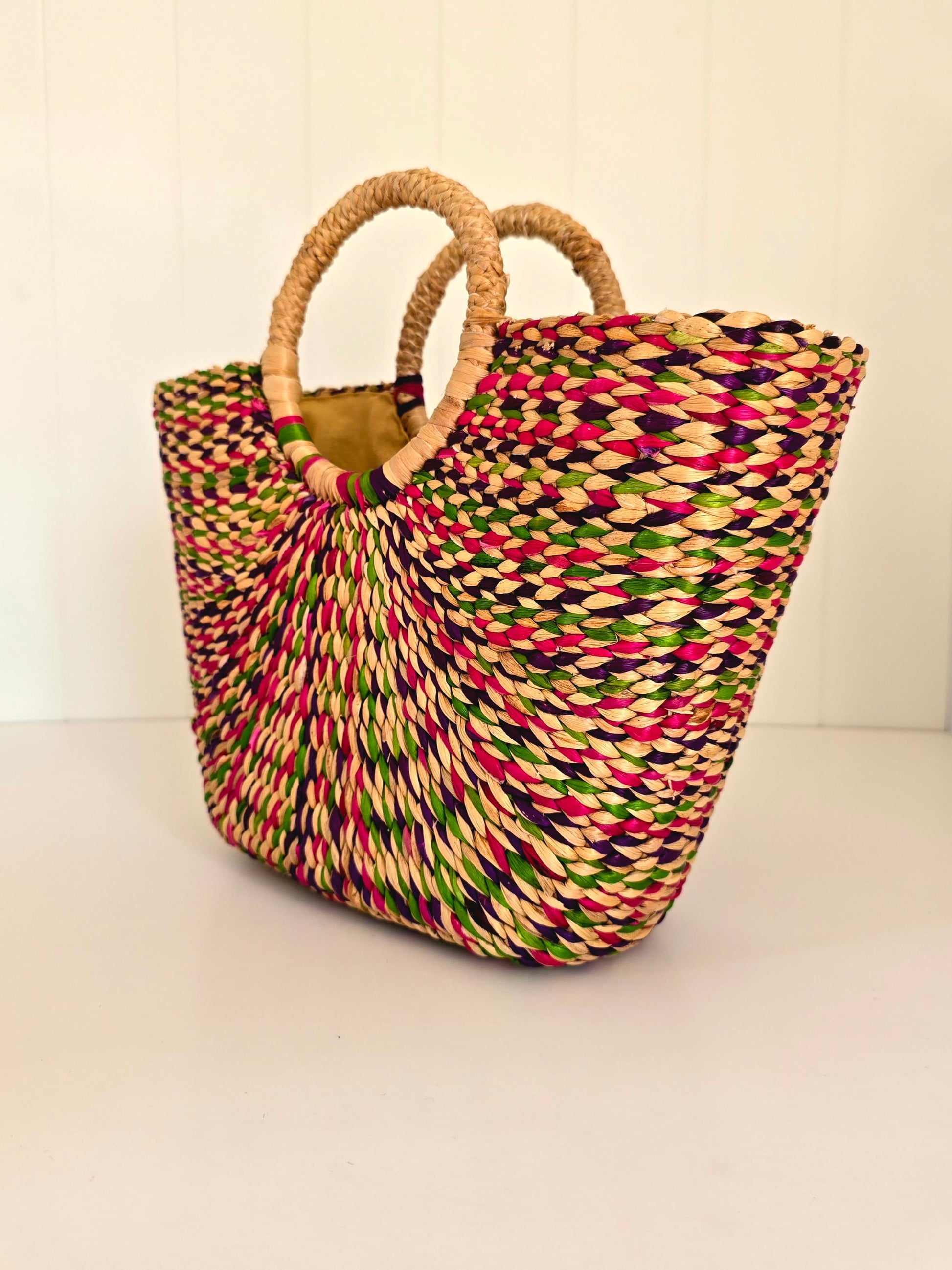Colorful woven bag with natural handle on a light background