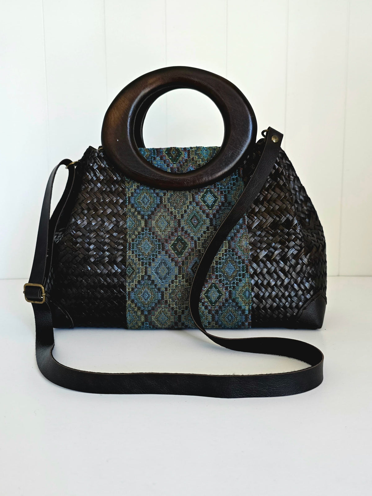 Handbag with woven pattern and wooden handle on a white background